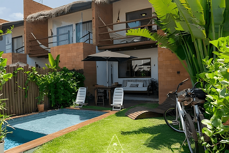 Casa de dois andares com varandas, redes e piscina no jardim