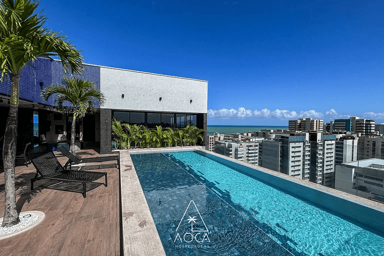 Piscina de borda na cobertura com vista para os prédios de Maceió