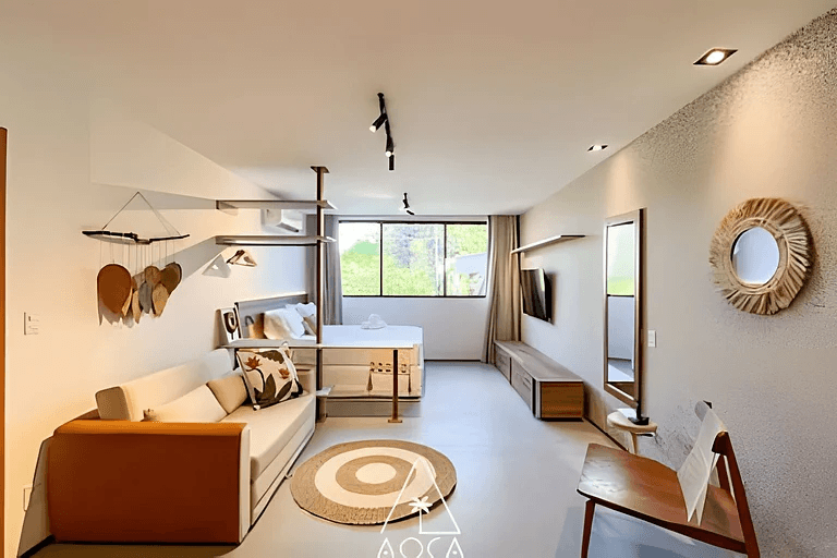 Sala integrada do studio com decoração em tons naturais