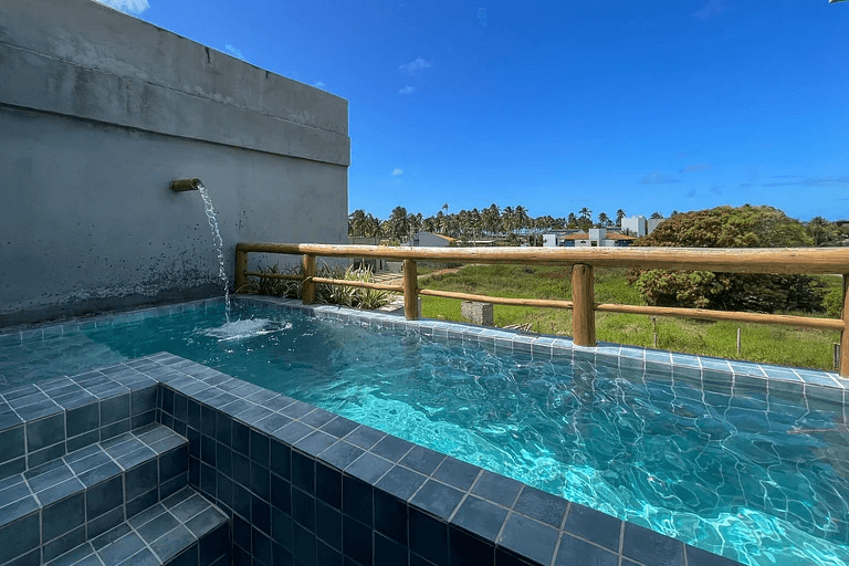 Piscina privativa com cascata no terraço do triplex